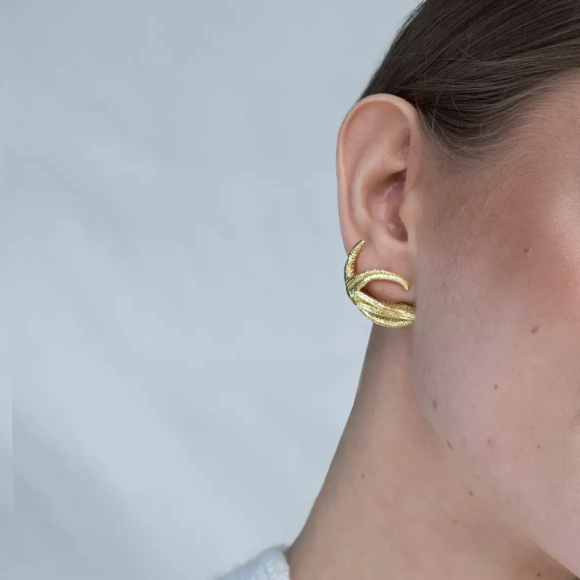 Asymetryczne, złote kolczyki rozgwiazdy z kolekcji Maris